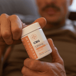 man holding cbg gummies bottle up close