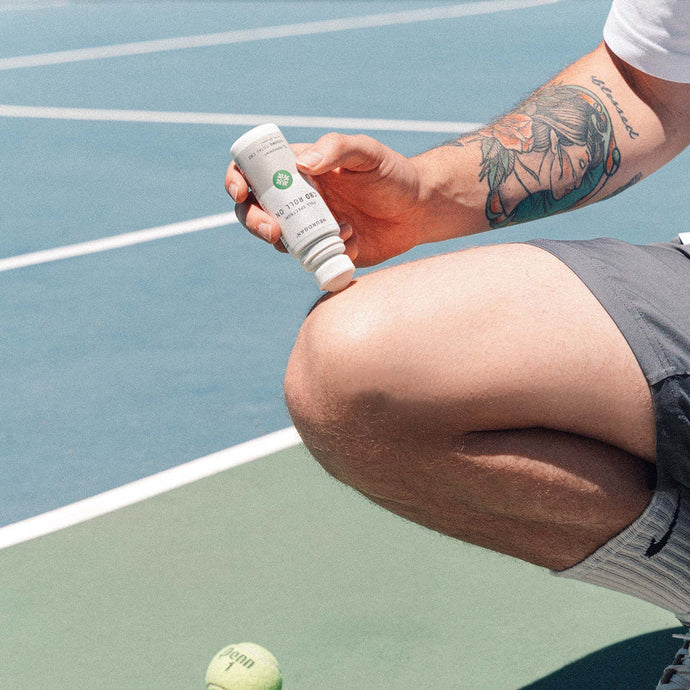 Neurogan CBD Freeze Roll On being applied to the knee of a tennis player