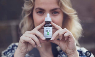 A woman holding a bottle of Neurogan CBD Oil 