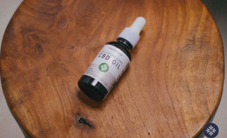 Neurogan CBD Oil laying on a round wooden tab