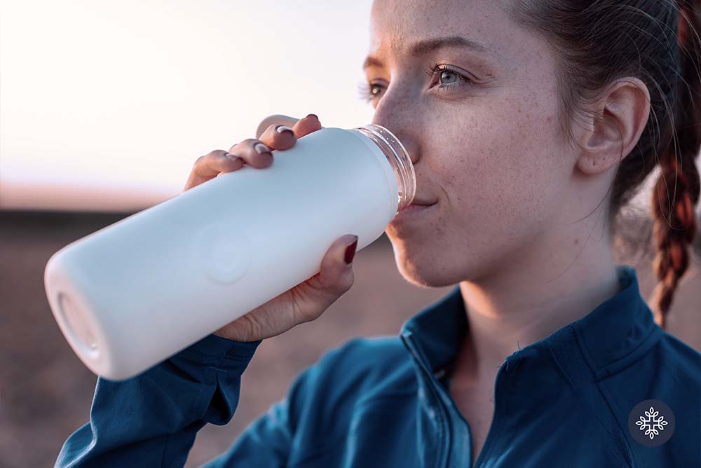 Woman drinking water from her white tumbler