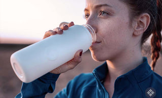 Woman drinking water from her white tumbler