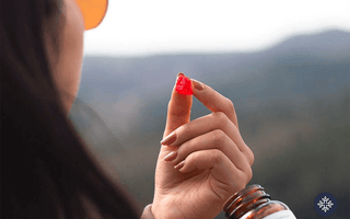 A woman on a mountain taking a CBD gummy