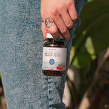 A person holding a bottle of THC-Free CBD Gummies by its lid