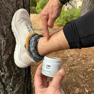 Woman applying CBD Balm on ankle