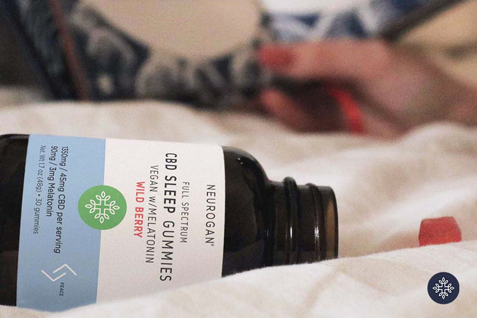 CBD Sleep Gummies bottle laying on a bed with white sheet