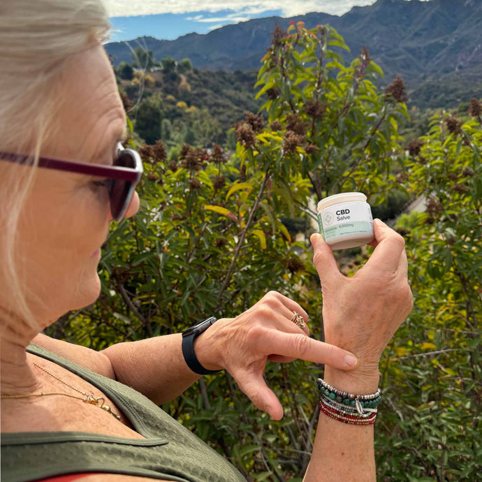 Elder woman applying CBD Salve on her wrist