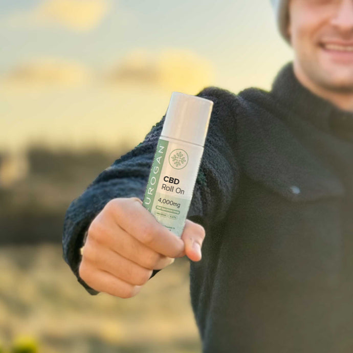 Man smiling holding a CBD Roll On