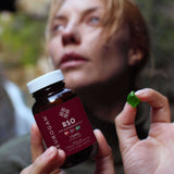 A woman holding an RSO Gummy and a bottle