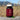 A bottle of RSO gummies on a rock with a wheatfield scenery