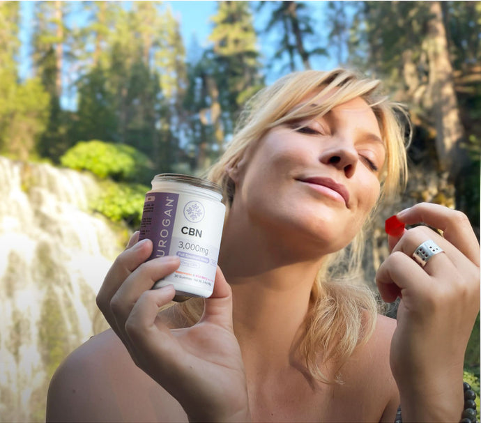 Woman holding CBN gummies, natural waterfalls setting