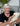 Smiling grandma holding a newborn baby, both cozy and happy, showcasing a loving family moment.