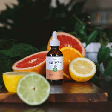 CBG Focus oil Citrus flavor on a wooden board with slices of orange, lemon and lime
