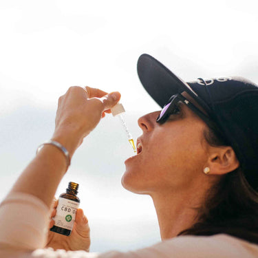 Woman pouring CBD oil into her mouth