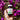 hand holding CBD + CBG Gummies in brown jar with purple flowers in background
