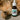 Bottle of CBD cat oil beside a cat laying on couch