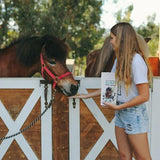 Woman holding a piece of CBD horse chews full spectrum on her hand to feed to her horse 